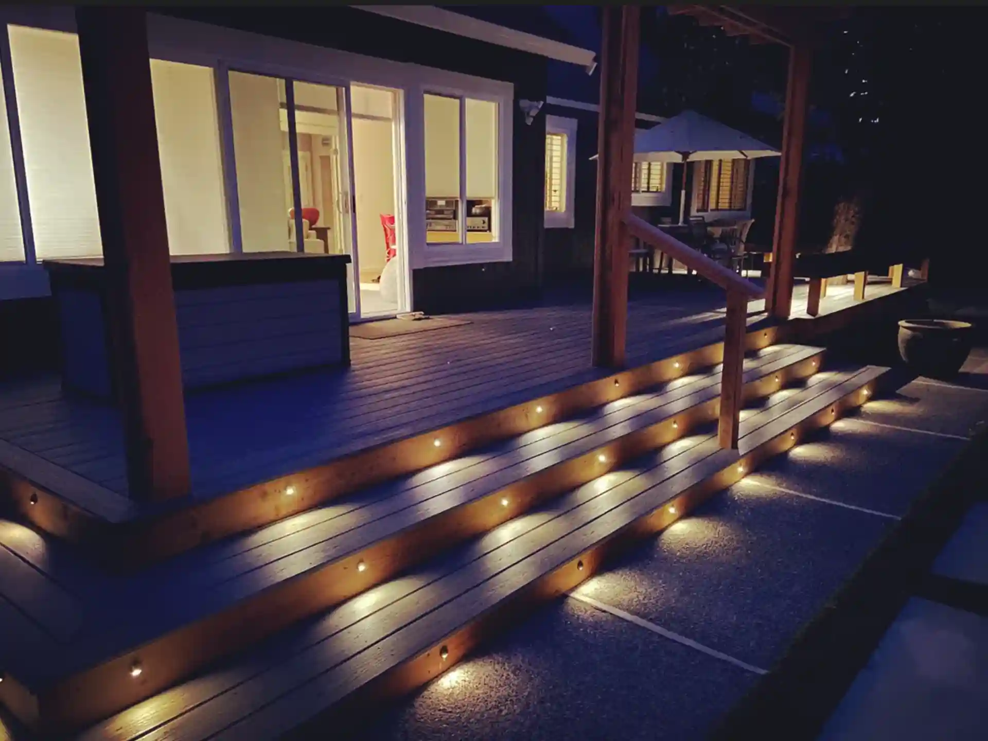 Deck with stairs illuminated by LED lights, creating a warm ambiance at night. 